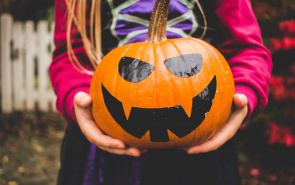 Child holding Halloween pumpkin