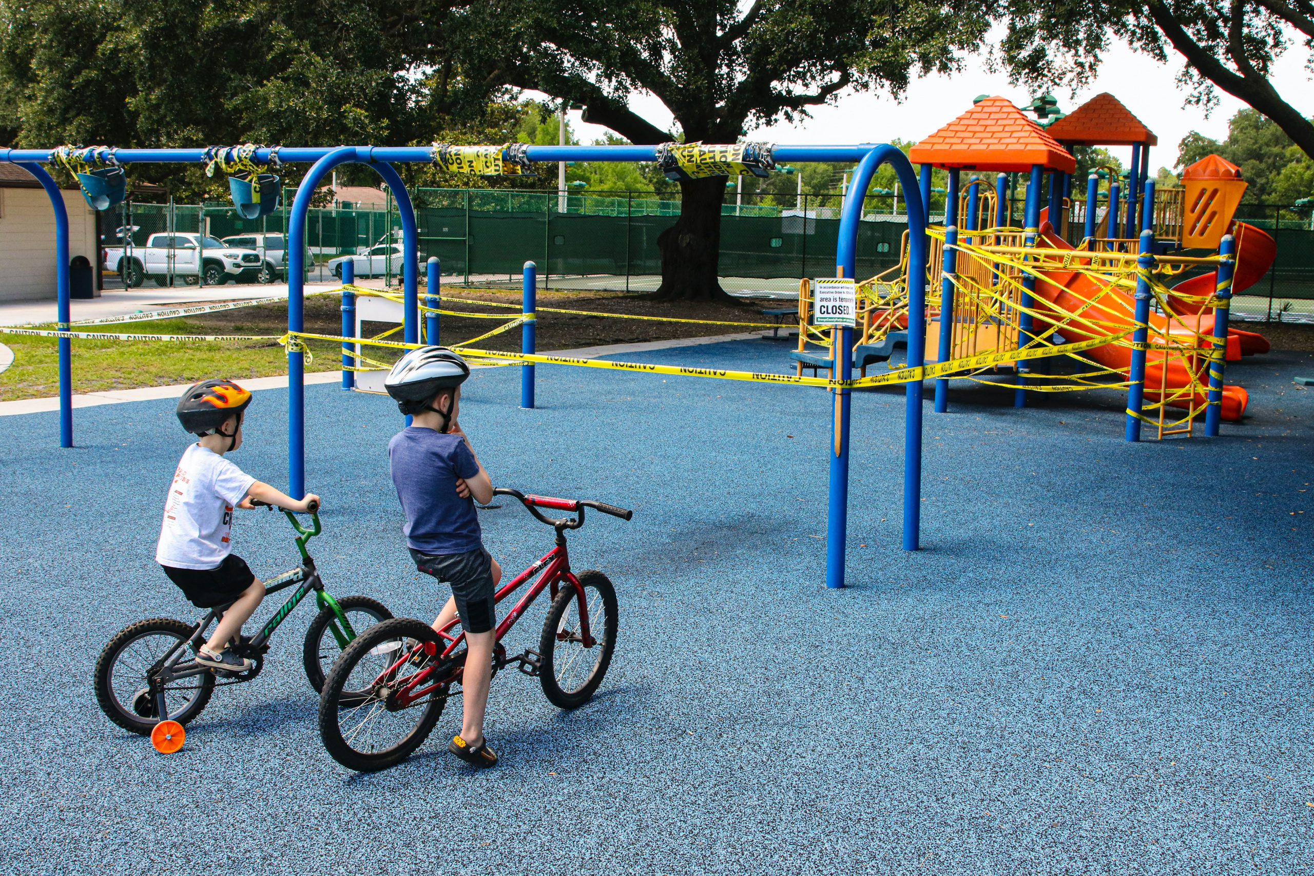 Children staring at closed playground equipment