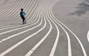 child scooting down big hill
