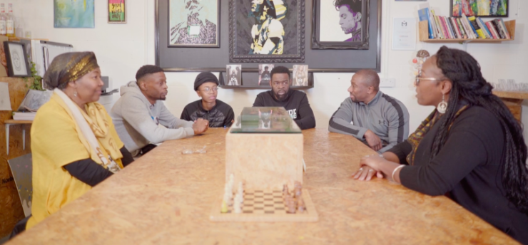 TAP Project discussion group A group of people sitting around a table discussing a film that they